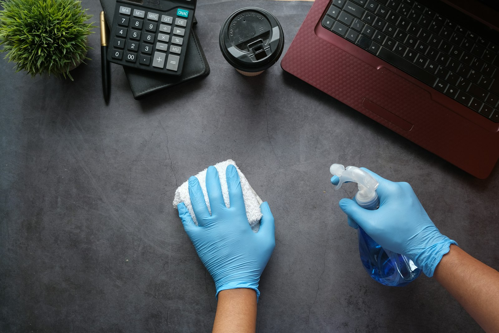 A cleaner sanitising an office desk